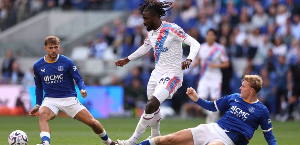 Crystal Palace player dribbling past Everton defenders