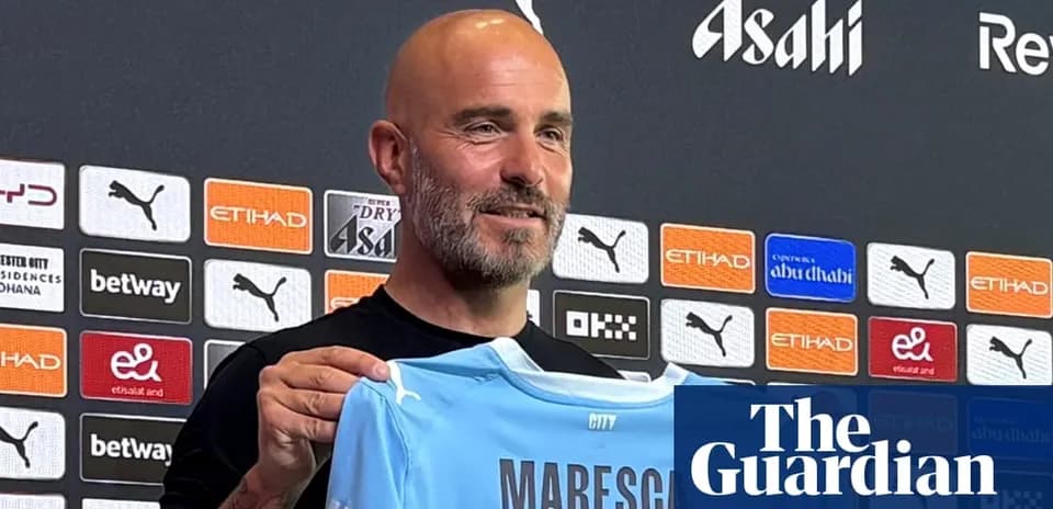 Man holding Manchester City jersey at press conference