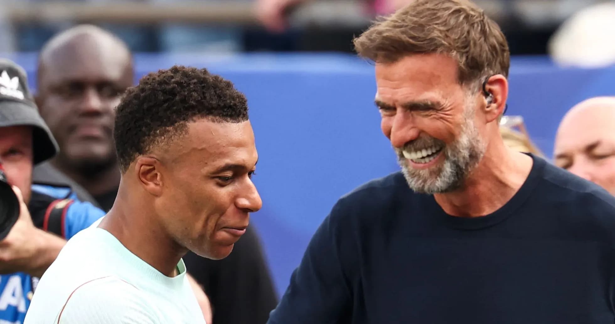 Kylian Mbappé and manager smiling during interaction
