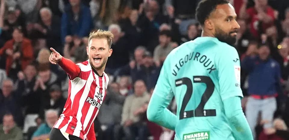 Player celebrating goal while opponent looks on