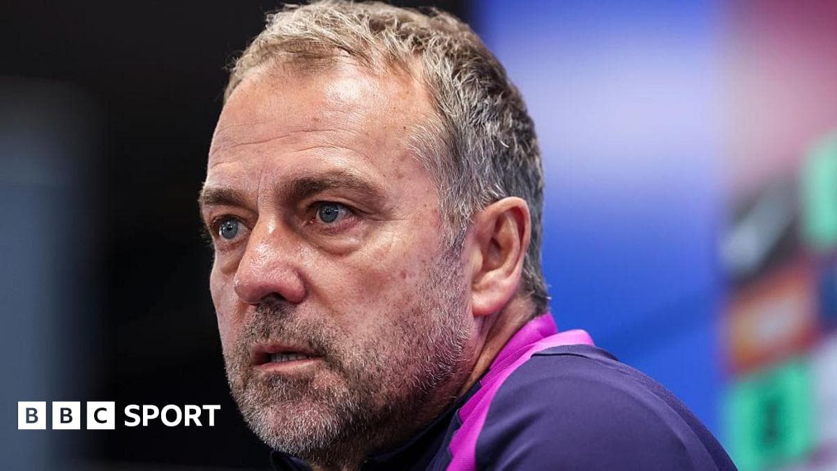 Coach speaking at press conference with serious expression