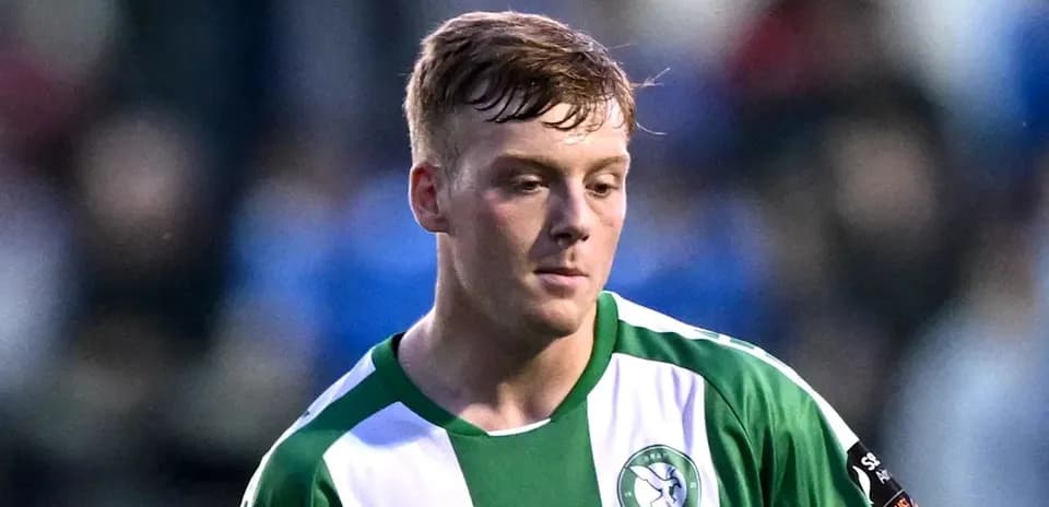 Player in green and white jersey on field