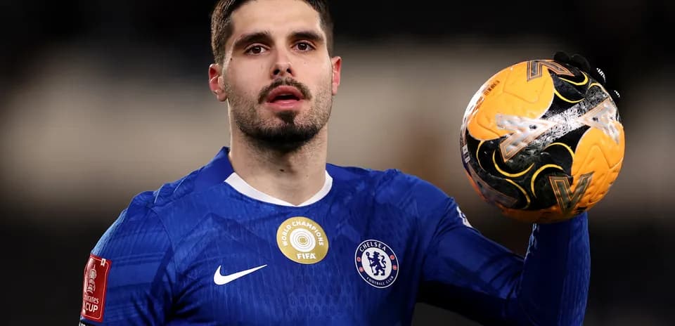 Chelsea player holding the match ball