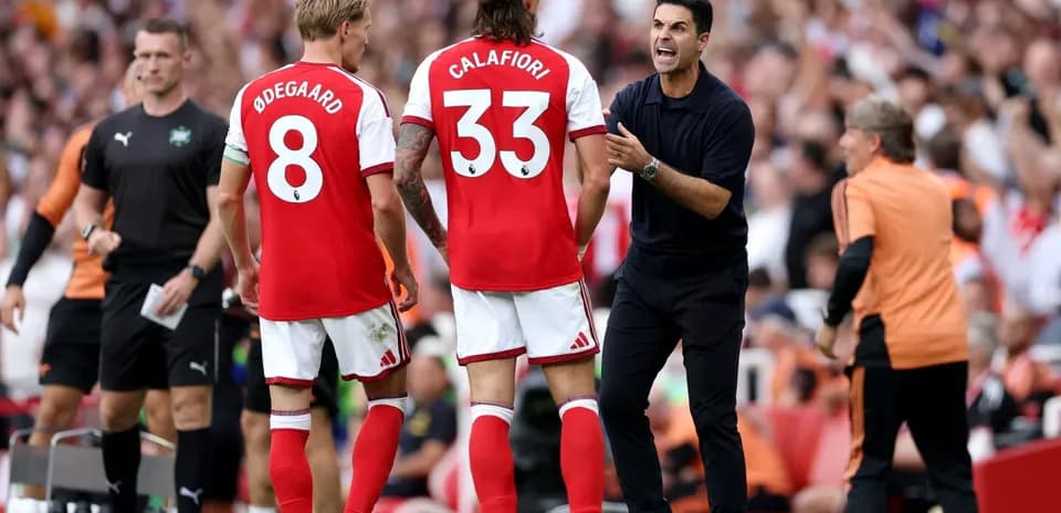 Arsenal players receiving instructions from the coach