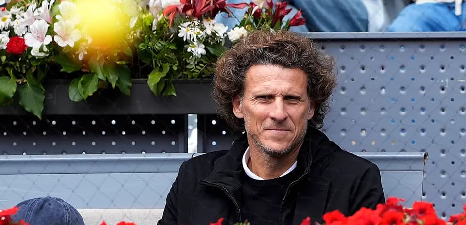 Man sitting among flowers at tennis match