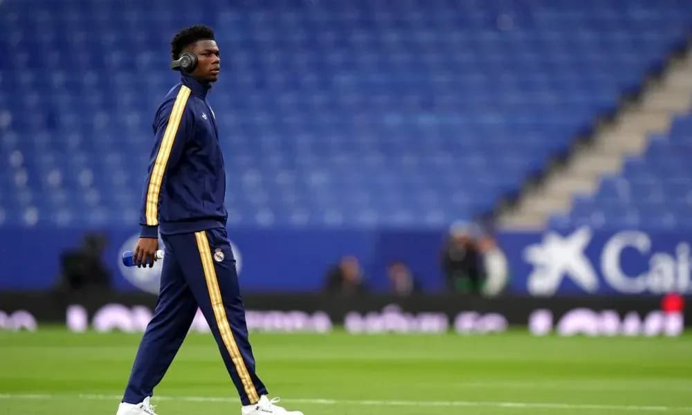 Player walking on pitch wearing headphones before match