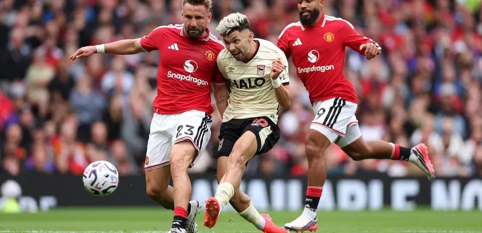 Manchester United players challenging Ipswich player for the ball