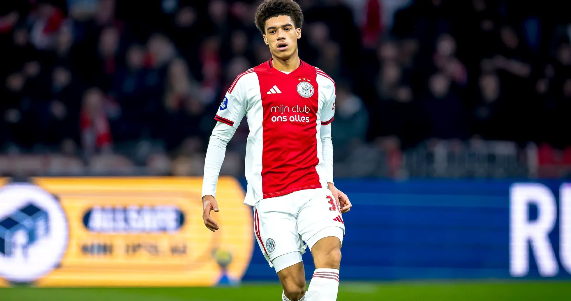 Player in Ajax jersey walking on the pitch