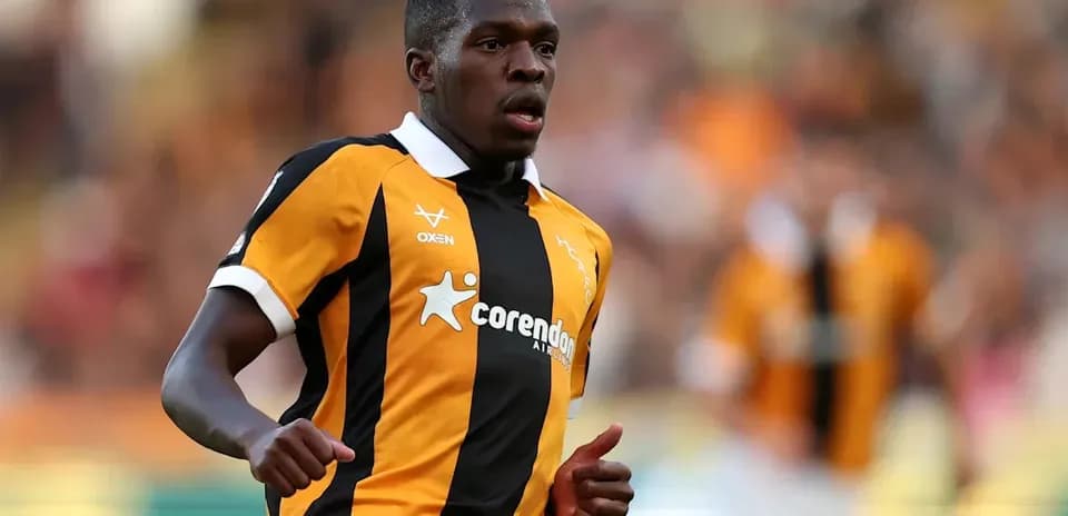 Player running in black and orange jersey during match