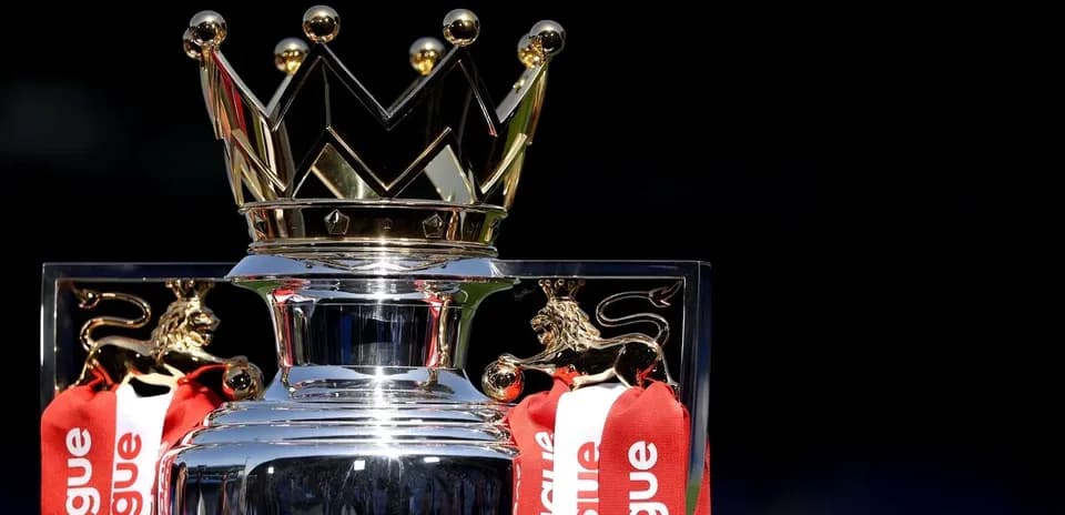 Premier League trophy with red ribbons displayed