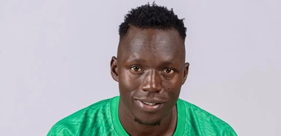 Goalkeeper posing in green kit against plain background