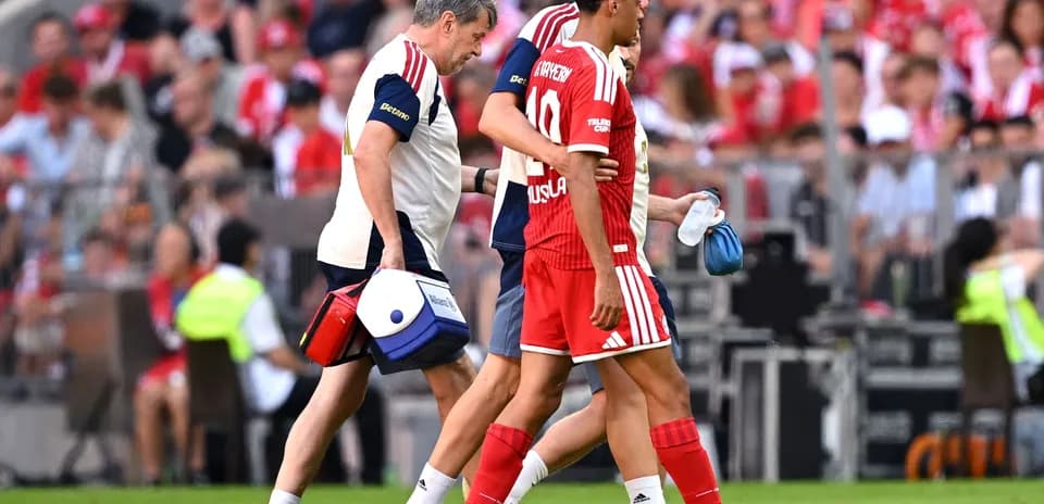 Player being assisted off the field by medical staff