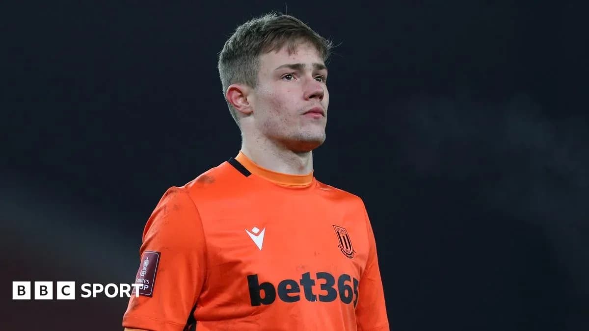 Goalkeeper in orange kit during match warm-up