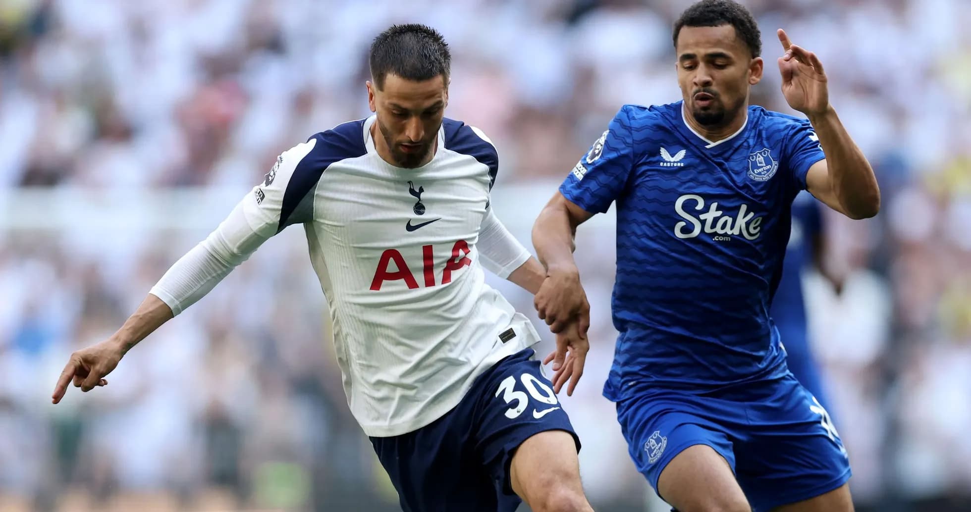 Tottenham player challenging Everton opponent for the ball