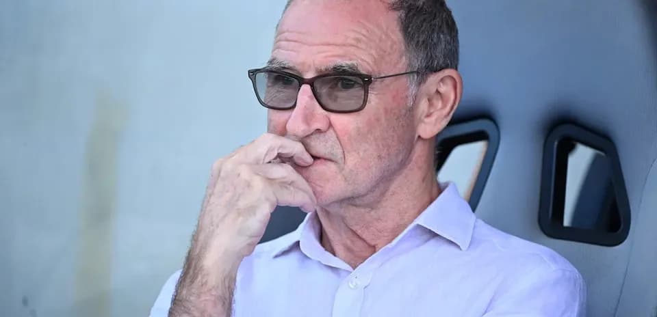 Man seated, wearing glasses, deep in thought