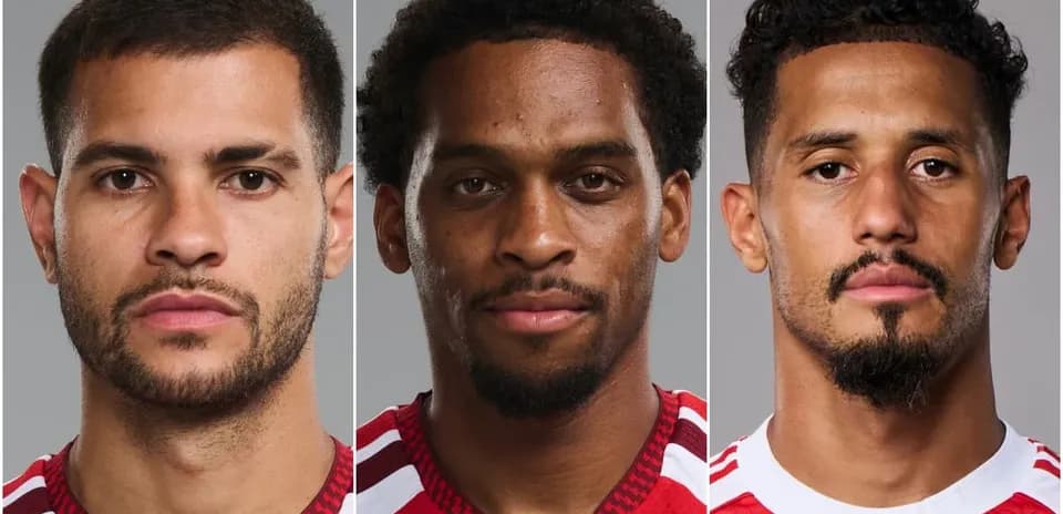 Three soccer players posing for portraits