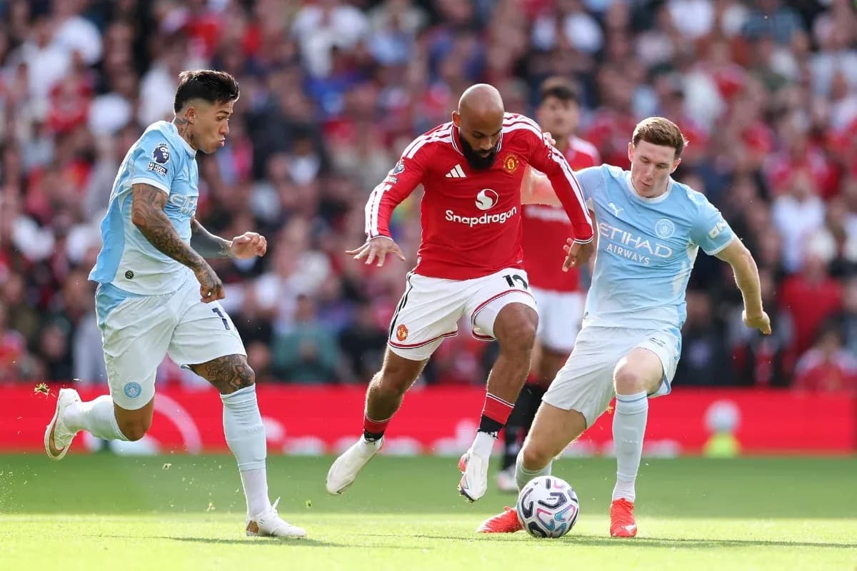 Manchester United player dribbling past Manchester City defenders
