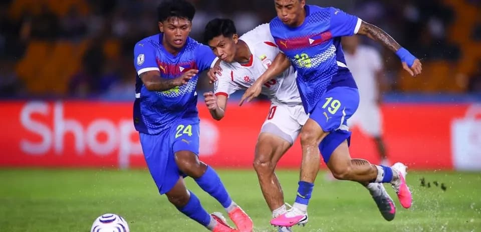 Two defenders tackling an opponent during football match