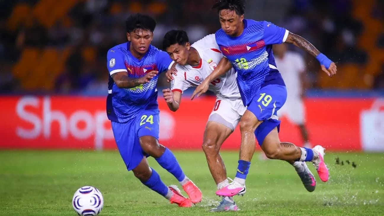 Two defenders tackling an opponent during football match