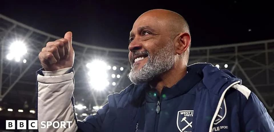 Manager celebrating with thumbs up in stadium