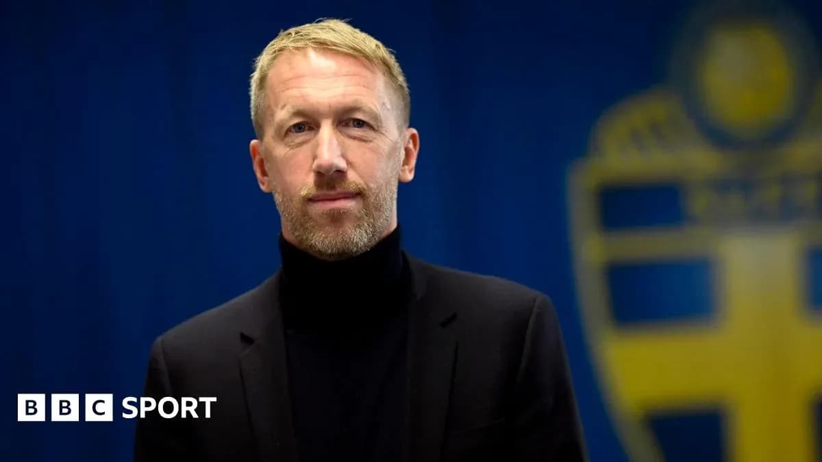 Man in suit standing in front of blue backdrop