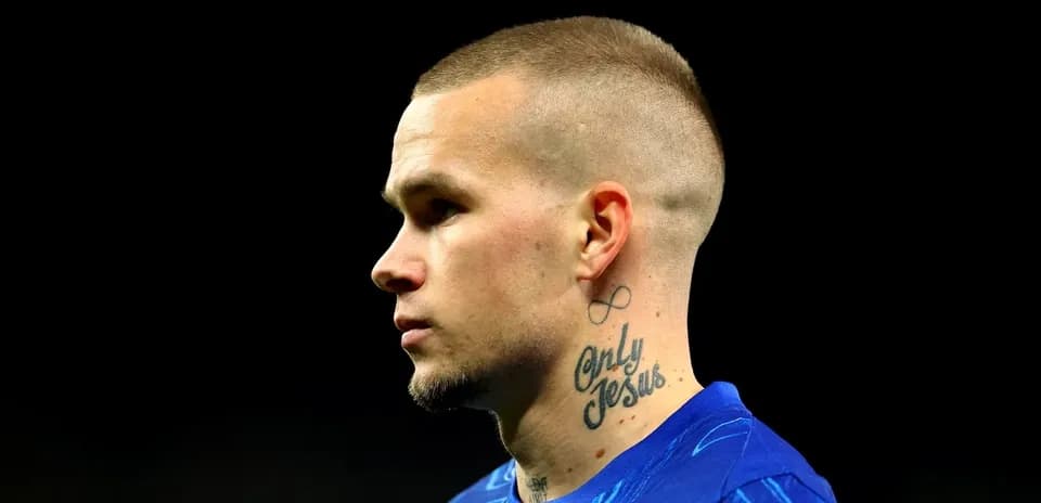 Player with tattoo wearing blue jersey in profile
