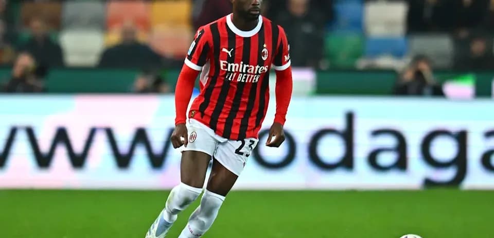 Player in AC Milan kit dribbling the ball