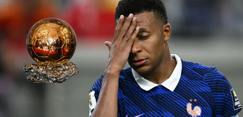 Player with hand on forehead near Ballon d'Or trophy