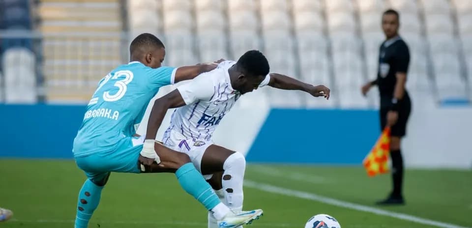 Goalkeeper challenges player during U23 football match