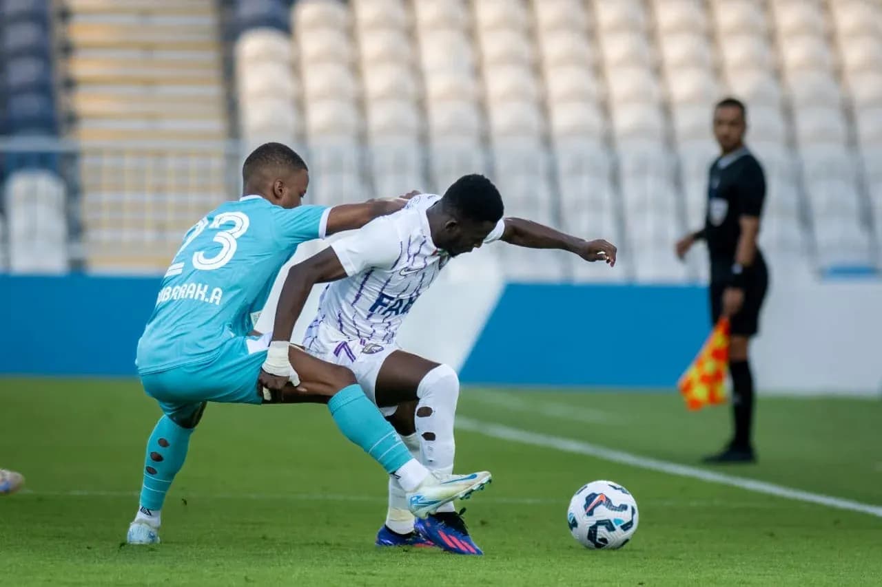 Goalkeeper challenges player during U23 football match