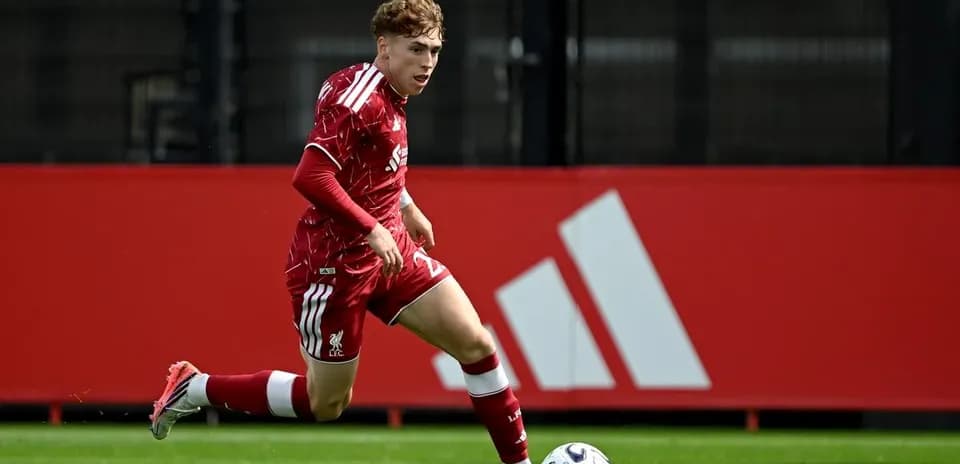 Player in red kit sprinting with soccer ball
