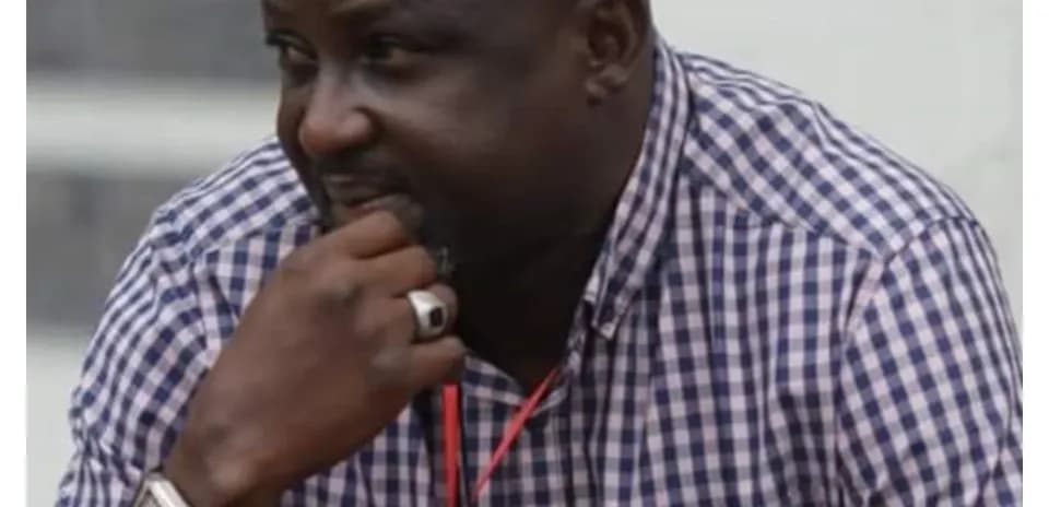 Man in checkered shirt observing an event