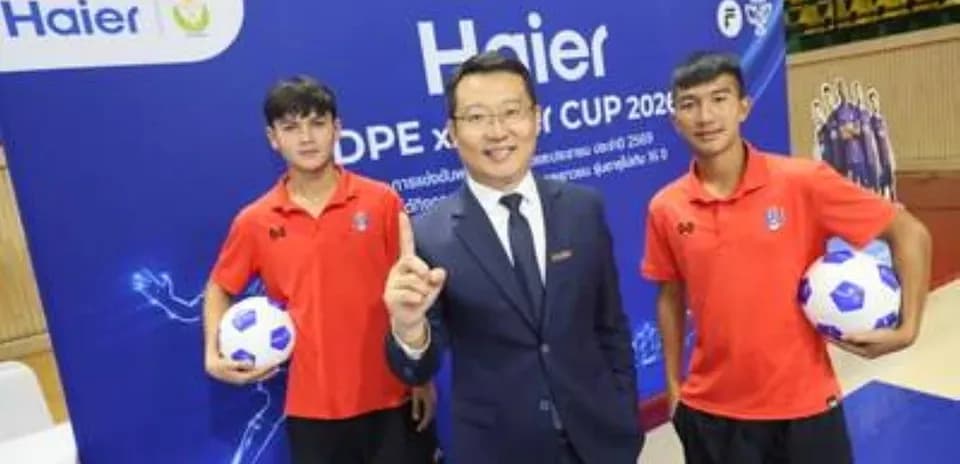 Two young players with a man in a suit