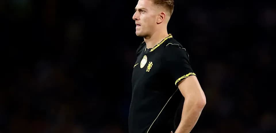 Player in black kit standing on the field