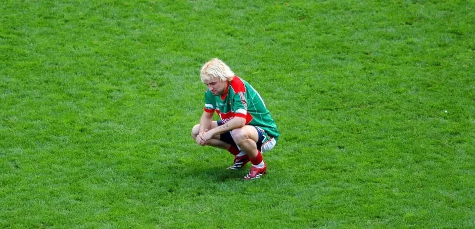 Player crouching on the field after a match