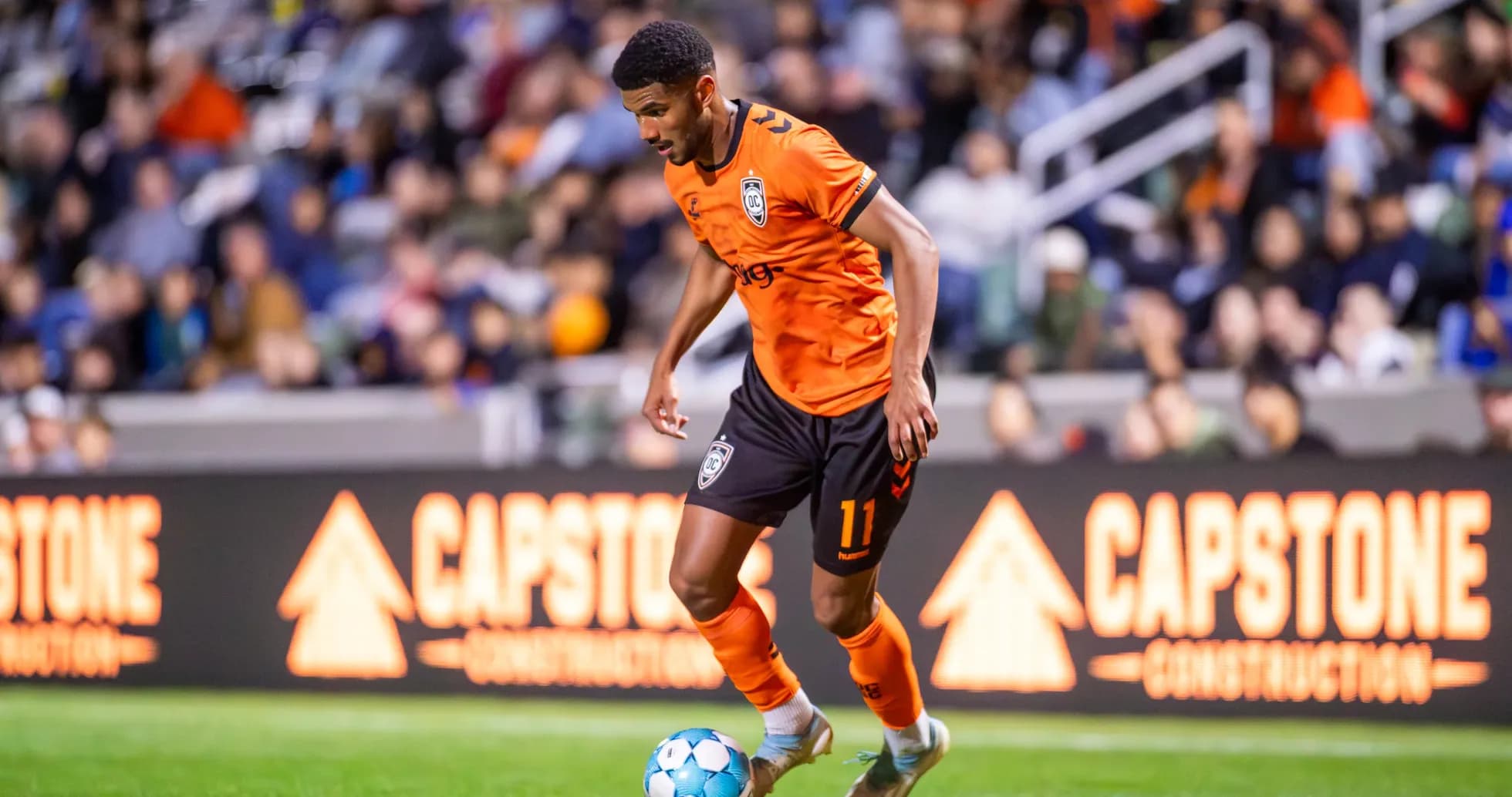 Orange County SC player dribbling during match
