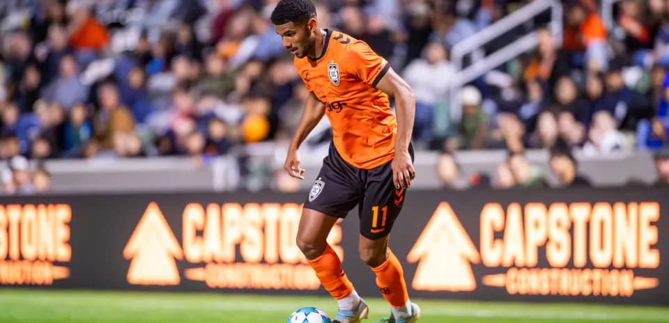 Orange County SC player dribbling during match