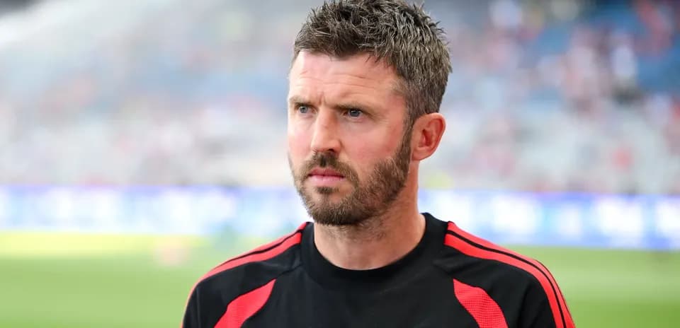 Coach in Manchester United training gear on pitch