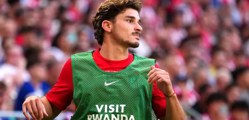 Player wearing training vest on sidelines during match
