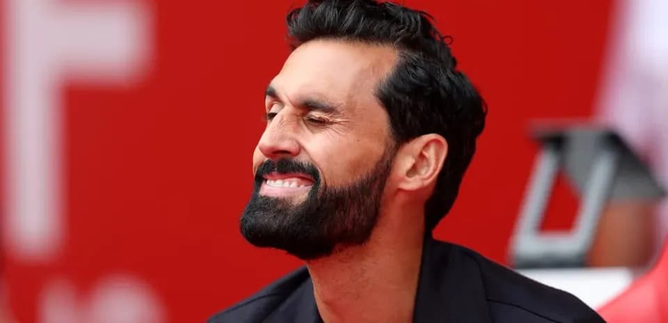 Man smiling while seated on the sidelines
