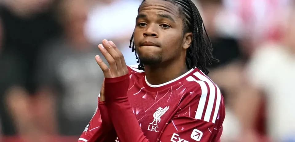 Player clapping in Liverpool FC jersey on field