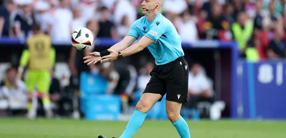 Referee throwing the ball during a football match