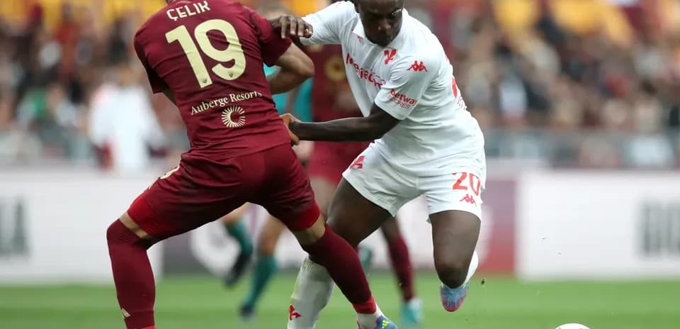 Celik and player battling for the ball