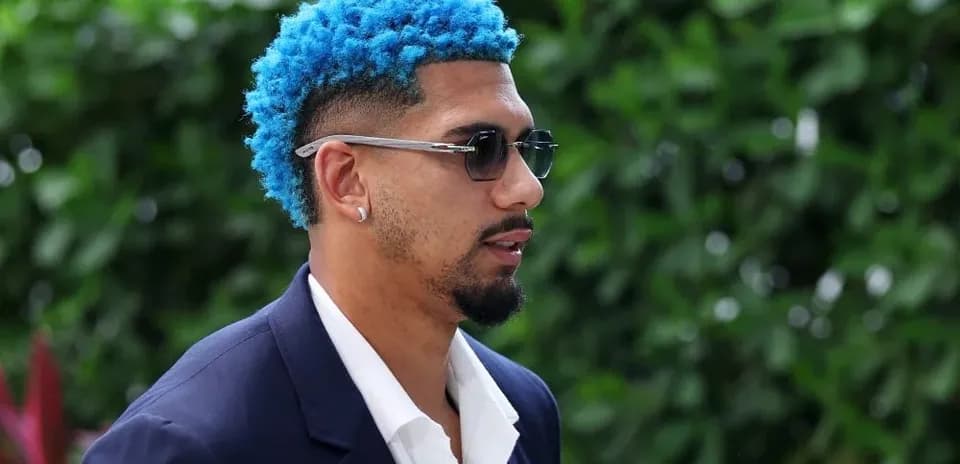 Person with blue hair wearing sunglasses and suit