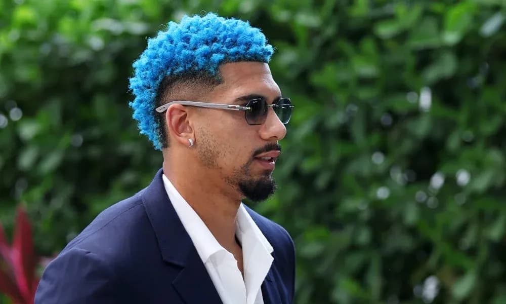 Person with blue hair wearing sunglasses and suit