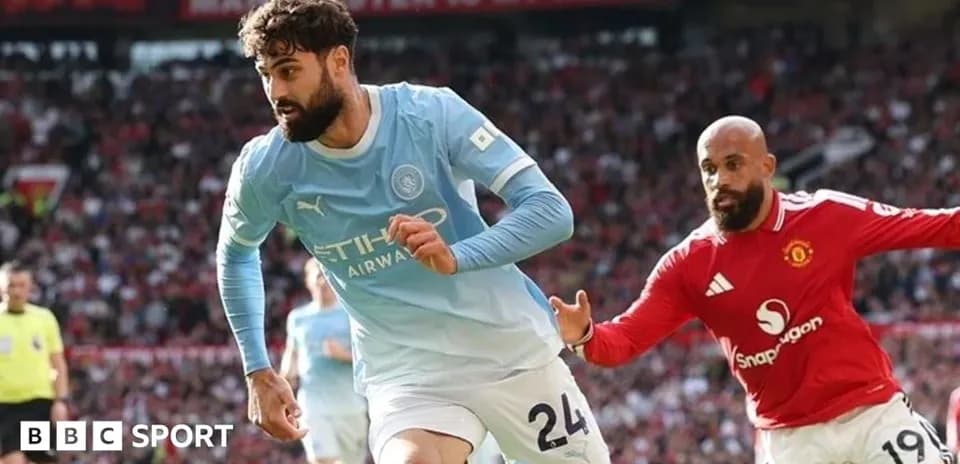 Manchester City player running from Manchester United opponent