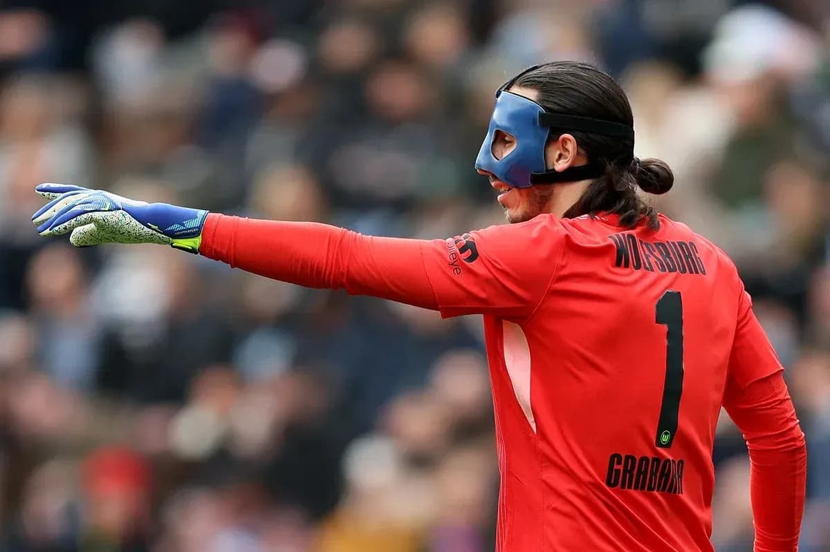 Goalkeeper in red jersey directing play during match
