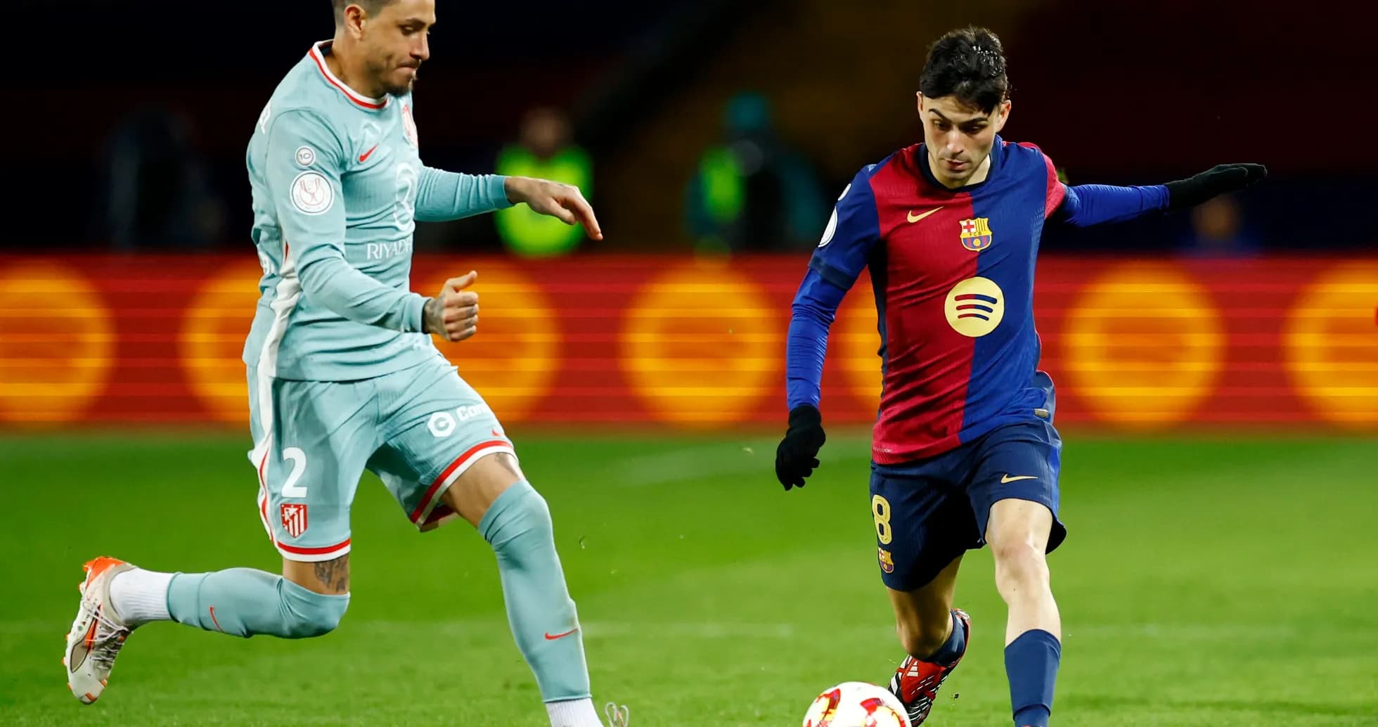 Atletico Madrid player challenging Barcelona midfielder