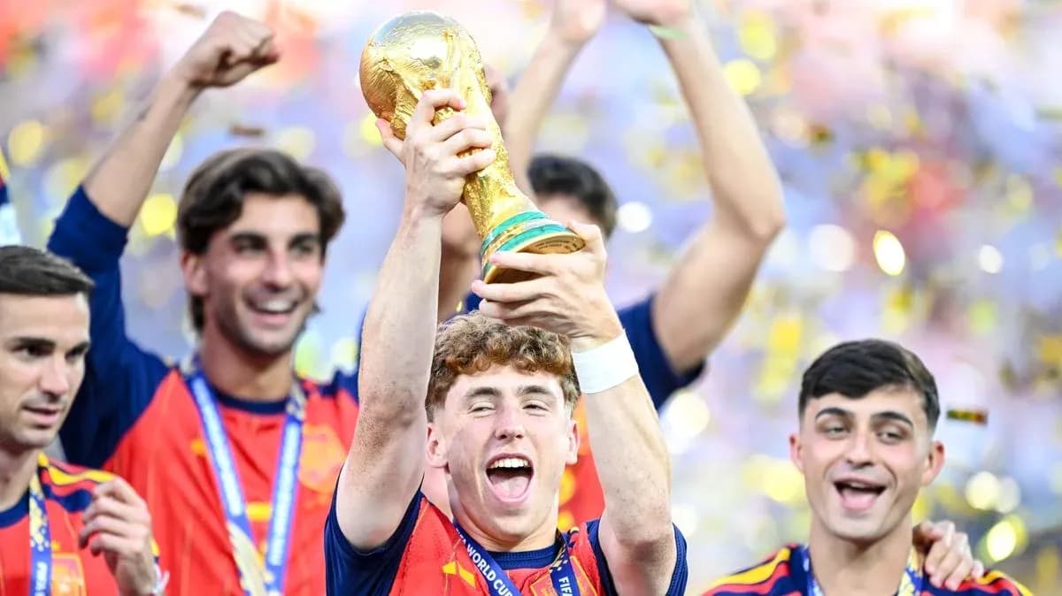 Player celebrating with FIFA World Cup trophy and teammates