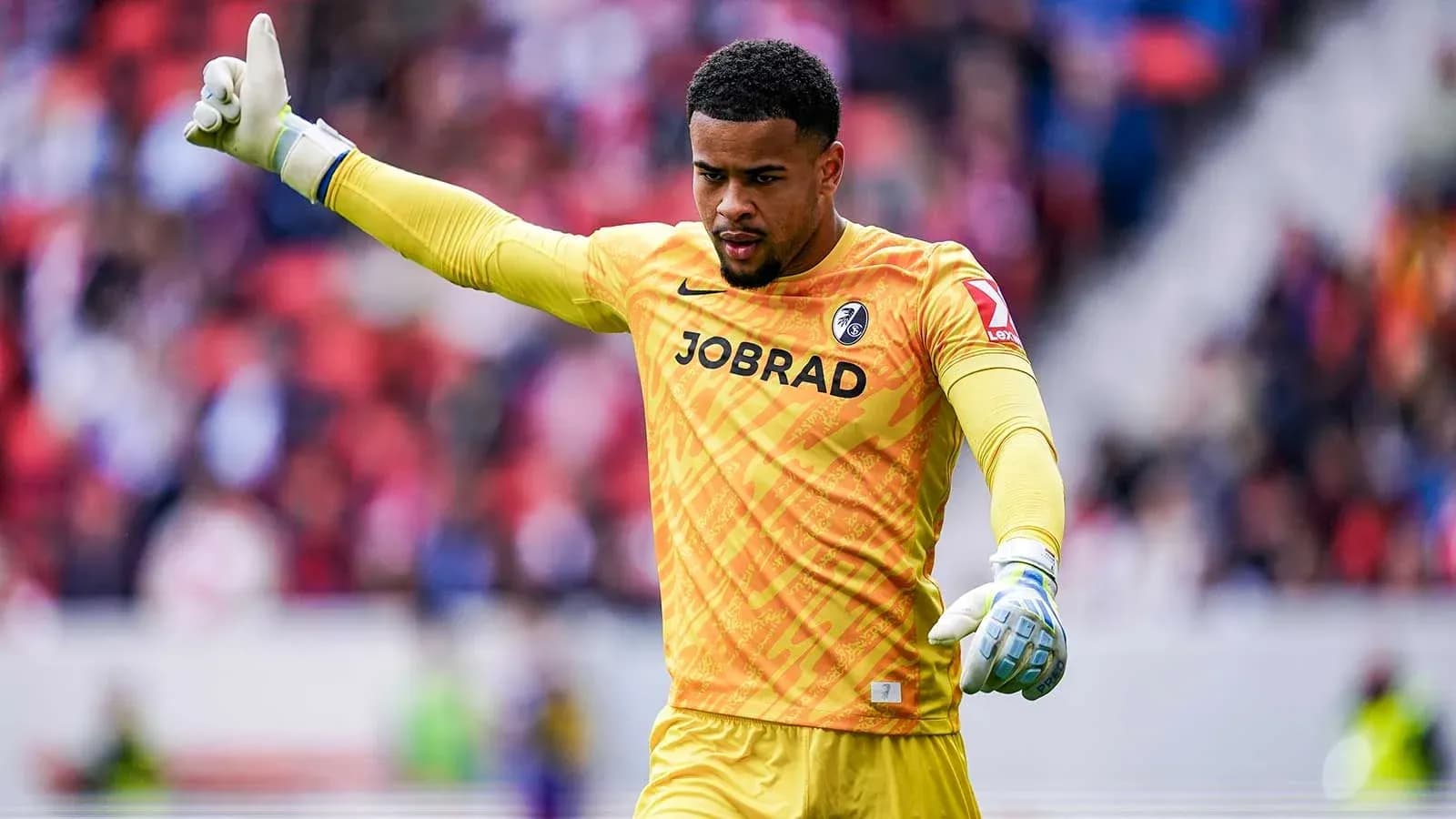Goalkeeper signaling during a match in yellow uniform